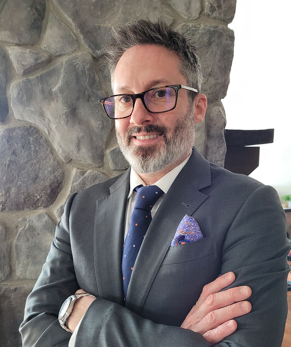 Asurtec professional man in suit smiling confidently IT and Data specialist for NFPs